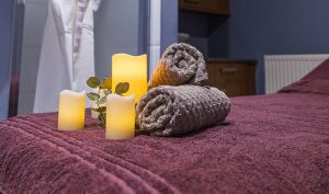 Towels and candles on spa treatment couch