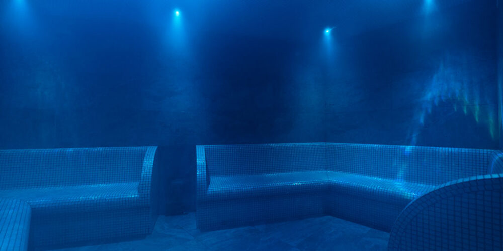 A steam room with mosaic benches and low level lighting.