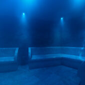 A steam room with mosaic benches and low level lighting.