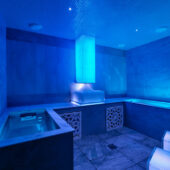 An ice experience room with an ice chute and blue cool lighting.