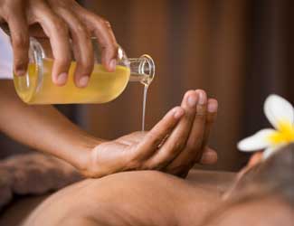 Aromatherpay massage oil blend with essential oils being poured
