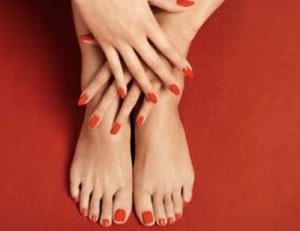Hands and feet with manicured red nails
