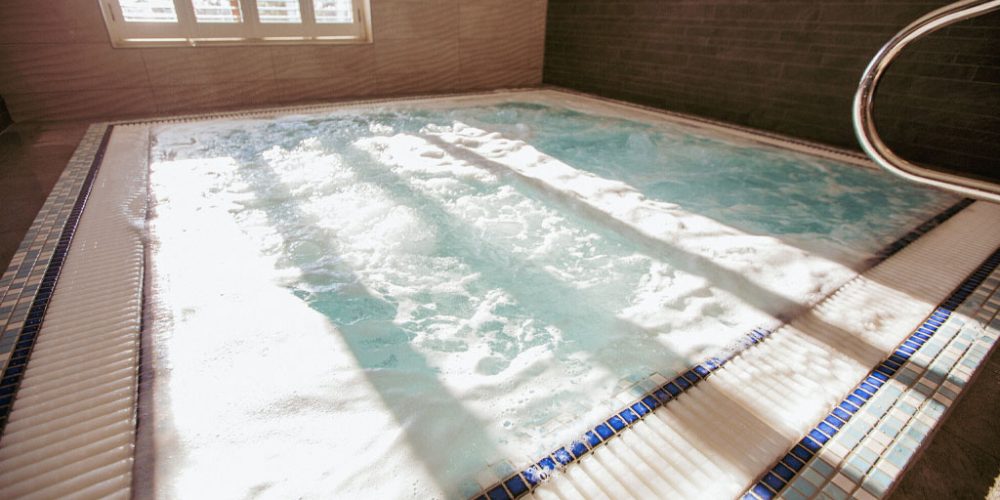 Moulton's spa pool, warm water bubbling with light shining through slatted blinds.